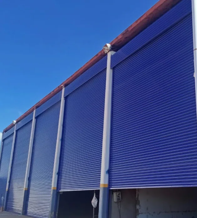 Porta azul de enrolar instalada em galpão