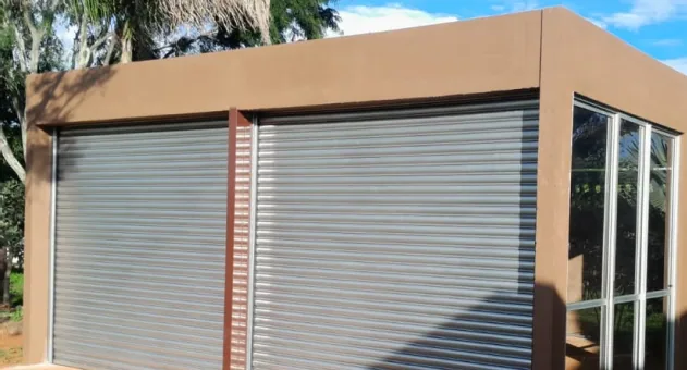 Porta de enrolar cinza instalada em fachada comercial